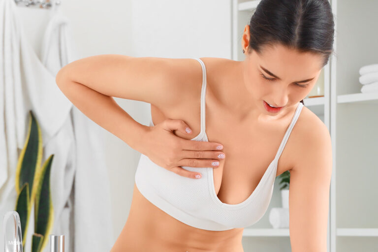 a woman holding her breast in pain